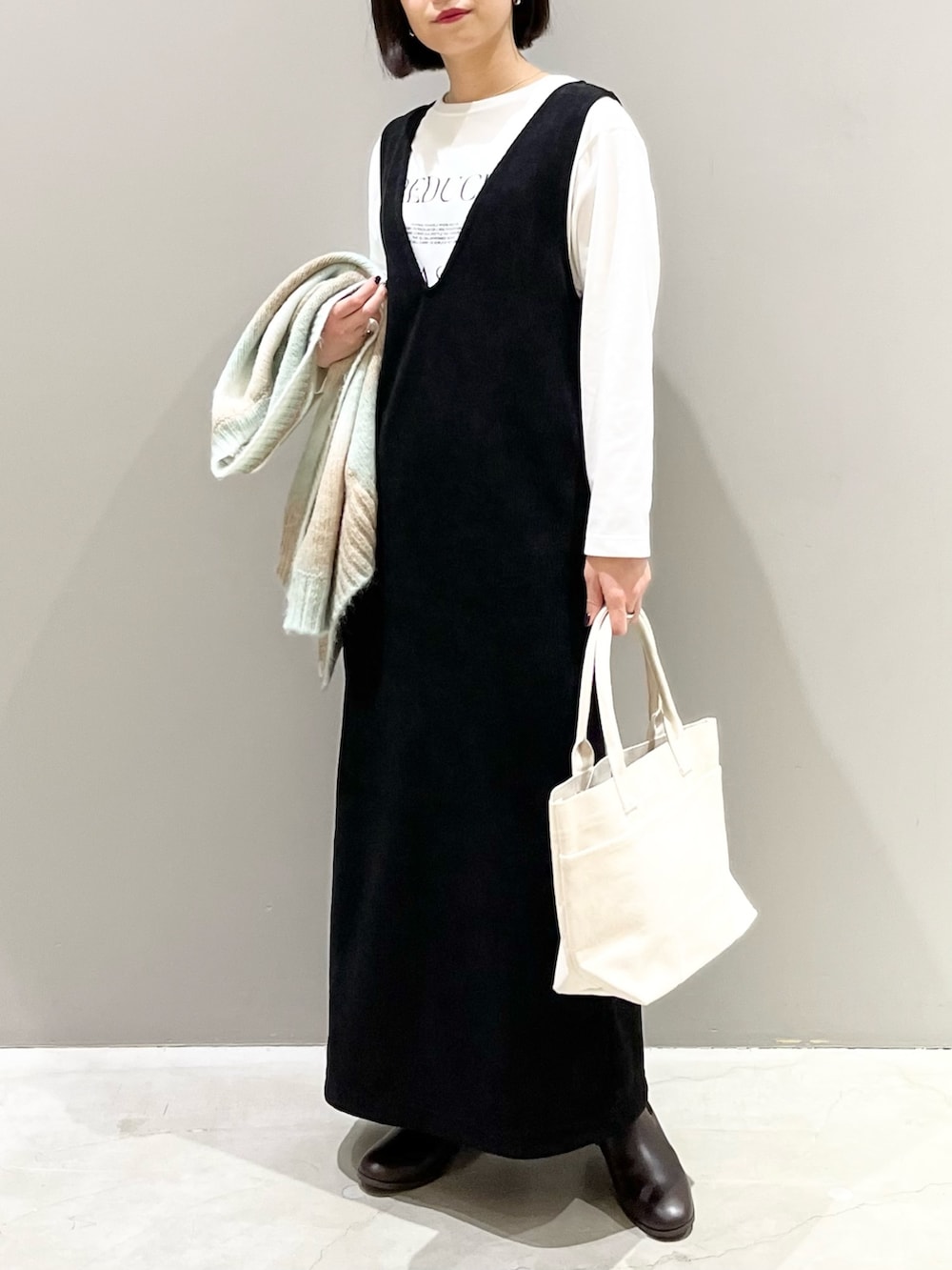 ブラック系のワンピース、グリーン系のカーディガン/ボレロ、ホワイト系のTシャツ/カットソーを着用したレディースの冬コーディネートの3枚目の写真