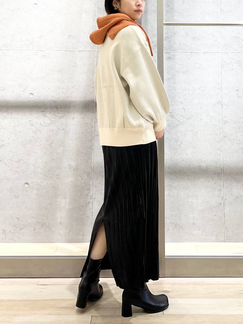 ブラック系のショルダーバッグ、ブラック系のブーツ、ホワイト系のニット/セーターを着用したレディースの秋コーディネートの4枚目の写真