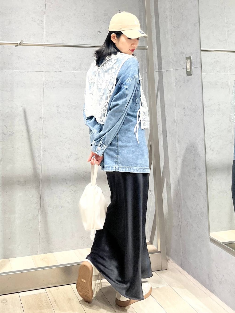 ブラック系のスカート、ブルー系のシャツ/ブラウス、ホワイト系のスニーカーを着用したレディースの冬コーディネートの2枚目の写真