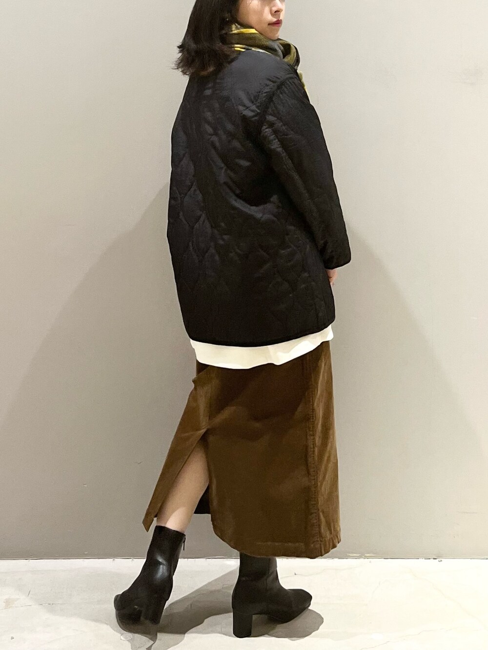 ブラウン系のスカート、ブラック系のブーツ、ブラック系のジャケット/アウターを着用したレディースの秋コーディネートの3枚目の写真