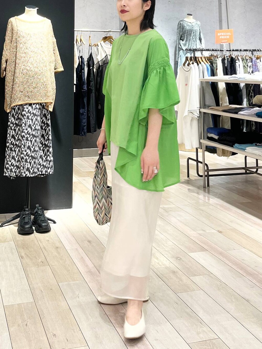 ホワイト系のハンドバッグ、ホワイト系のパンプス、ホワイト系のスカートを着用したレディースの春コーディネートの3枚目の写真