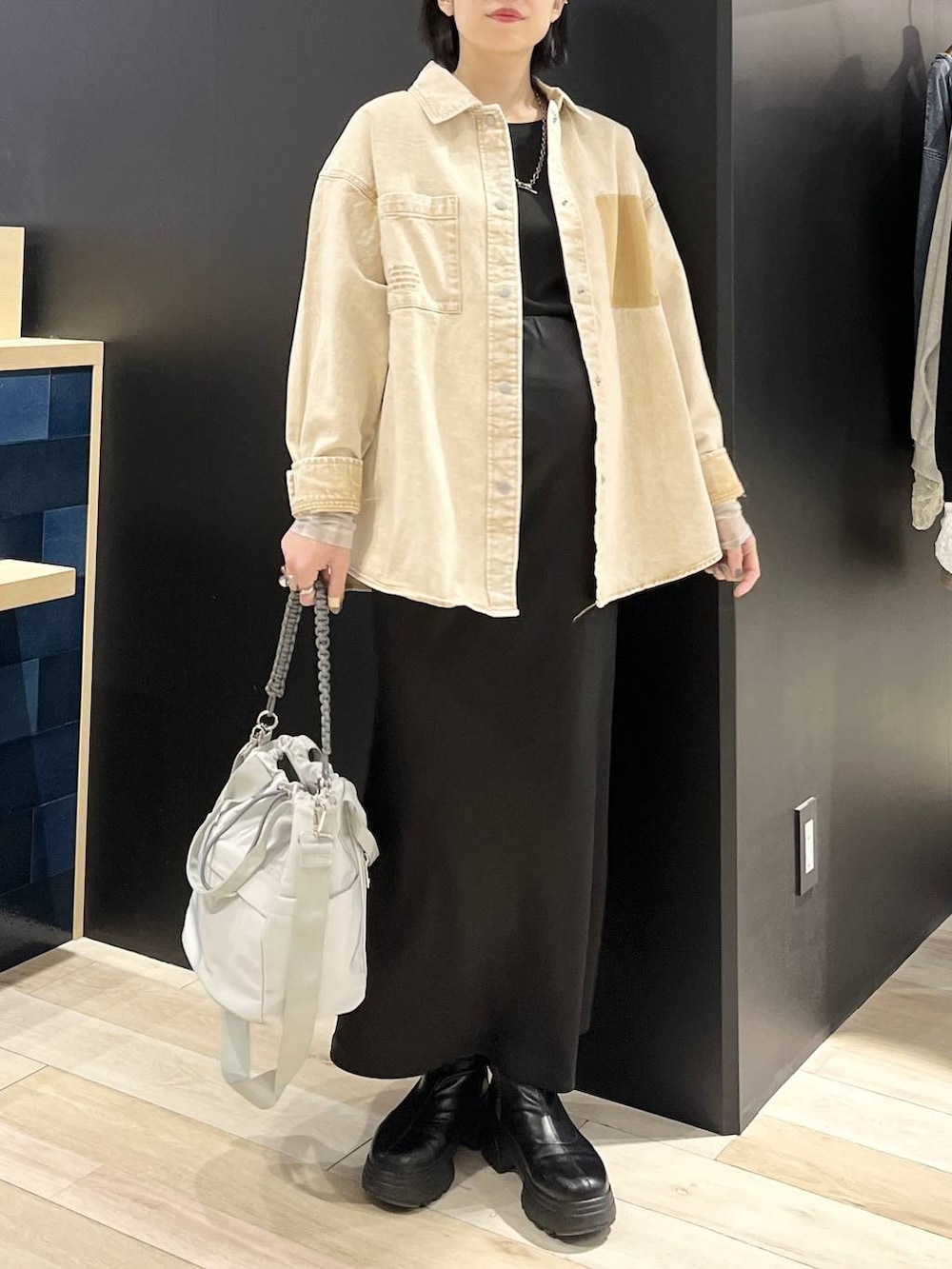 ブラック系のTシャツ/カットソー、ブラック系のスカート、ブラック系のブーツを着用したレディースの春コーディネートの2枚目の写真