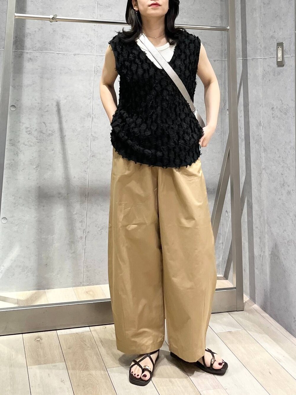 グレー系のショルダーバッグ、ホワイト系のTシャツ/カットソー、ベージュ系のその他パンツを着用したレディースの春コーディネートの6枚目の写真