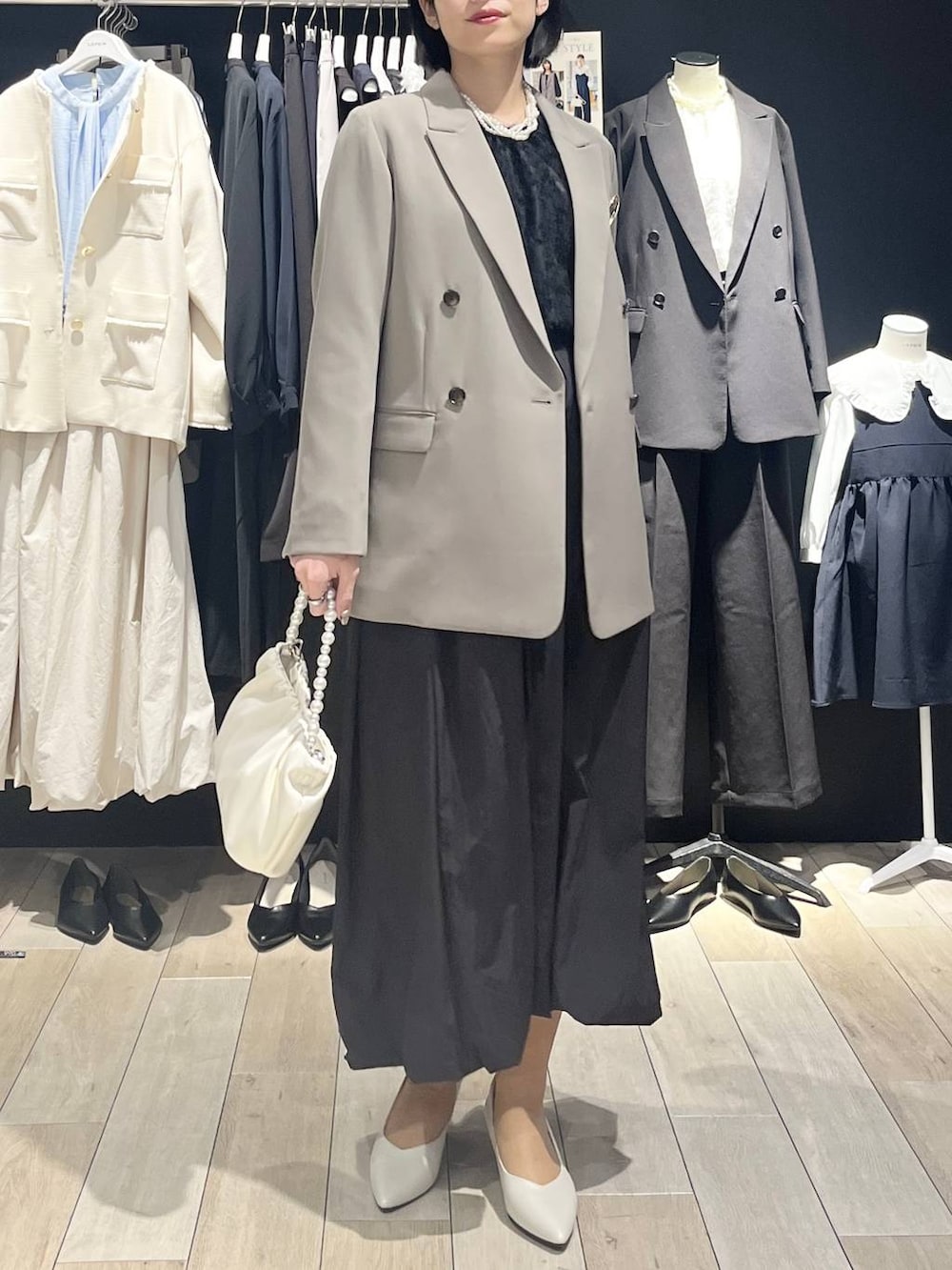 ブラウン系のテーラードジャケット、ブラック系のスカート、ブラック系のシャツ/ブラウスを着用したレディースの冬コーディネートの5枚目の写真