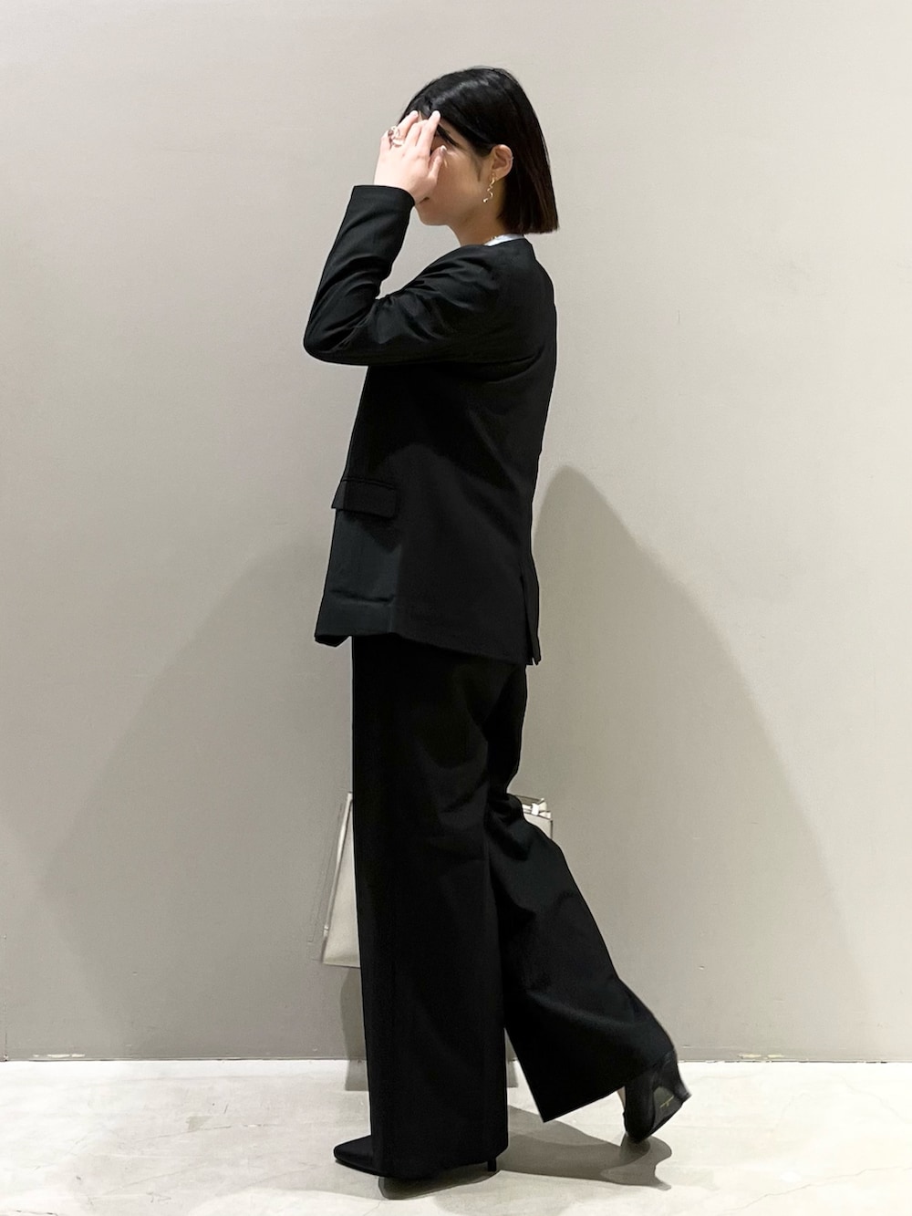 ブラック系のパンツ、ホワイト系のトートバッグ、ブラック系のパンプスを着用したレディースの冬コーディネートの3枚目の写真