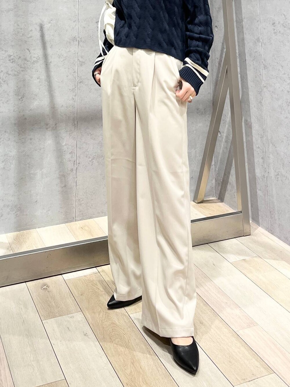 ブルー系のニット/セーター、ホワイト系のショルダーバッグ、ブラック系のパンプスを着用したレディースの冬コーディネートの7枚目の写真