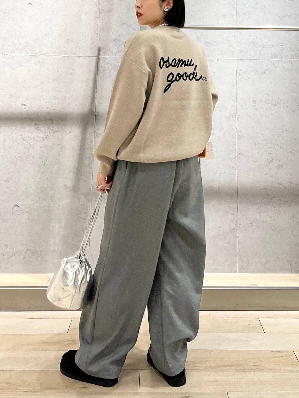 ブラック系のモカシン/デッキシューズ、グレー系のその他パンツ、ベージュ系のニット/セーターを着用したレディースの秋コーディネートの4枚目の写真