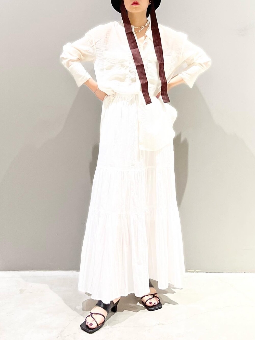 ホワイト系のスカート、ホワイト系のシャツ/ブラウス、ブラック系のサンダルを着用したレディースの夏コーディネートの7枚目の写真