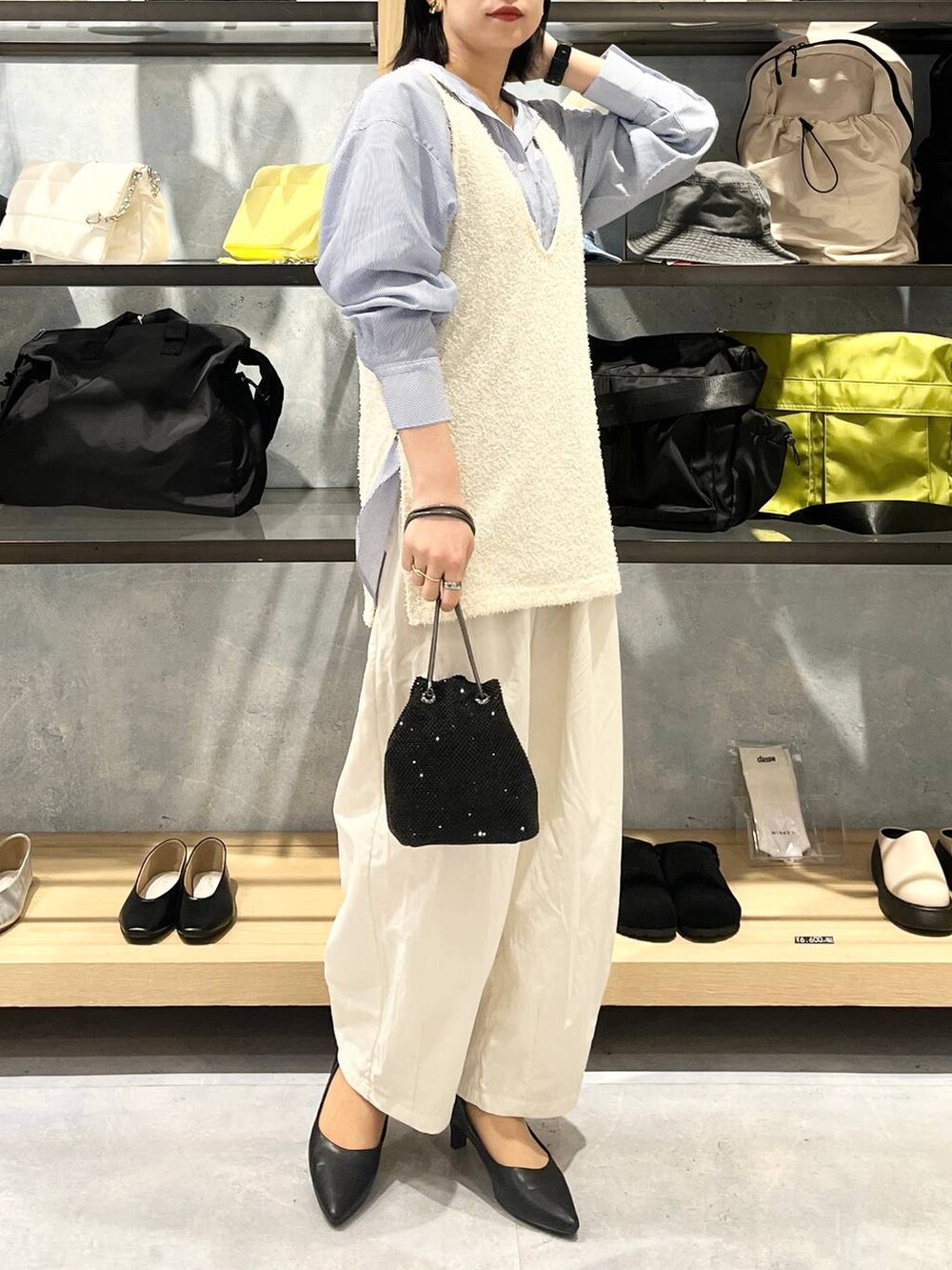 ブラック系のショルダーバッグ、ブラック系のパンプス、ブルー系のシャツ/ブラウスを着用したレディースの春コーディネートの8枚目の写真