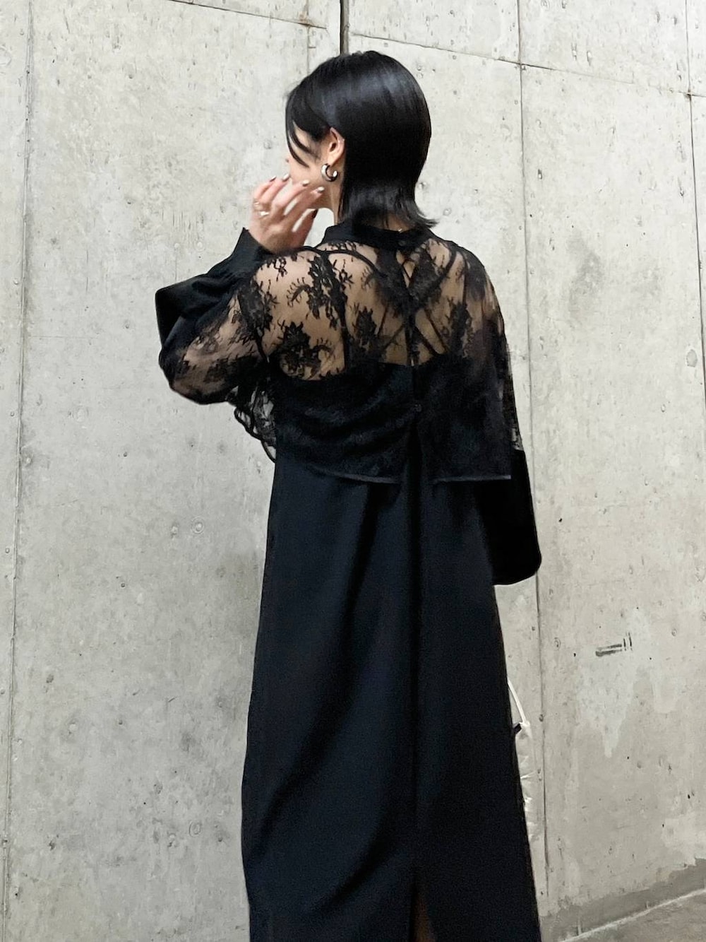 シルバー系のハンドバッグ、ホワイト系のパンプス、ゴールド系のネックレスを着用したレディースの春コーディネートの5枚目の写真