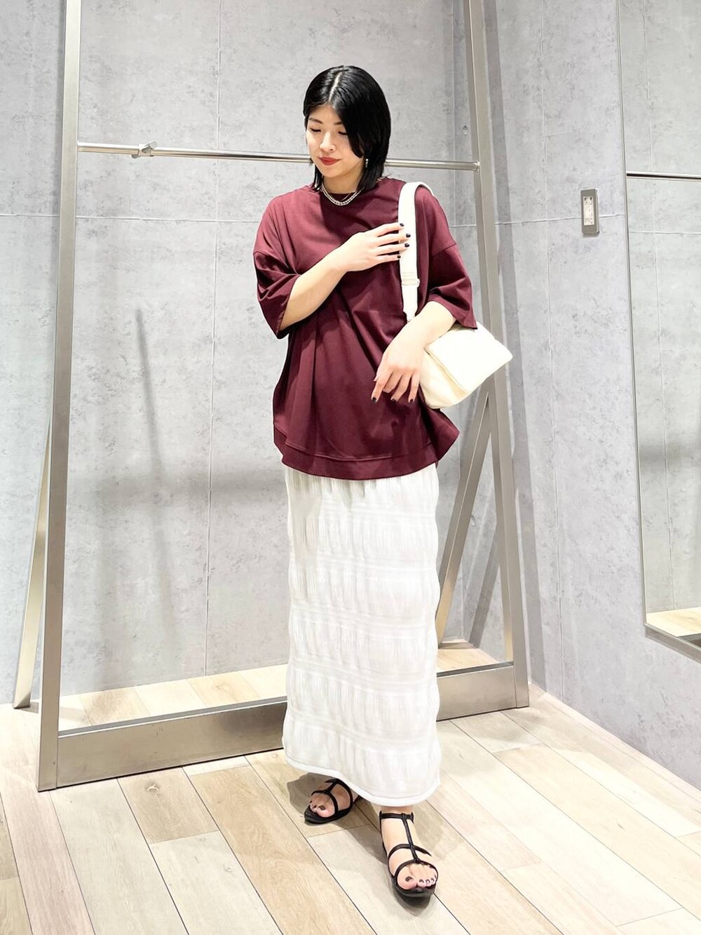 ホワイト系のショルダーバッグ、ブラック系のサンダル、レッド系のTシャツ/カットソーを着用したレディースの夏コーディネートの8枚目の写真