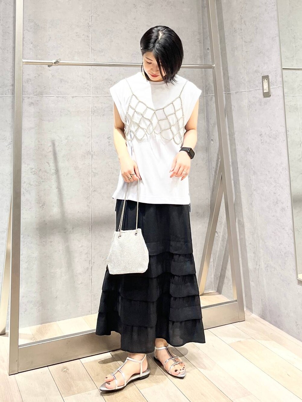 シルバー系のショルダーバッグ、ブルー系のTシャツ/カットソー、シルバー系のサンダルを着用したレディースの夏コーディネートの4枚目の写真