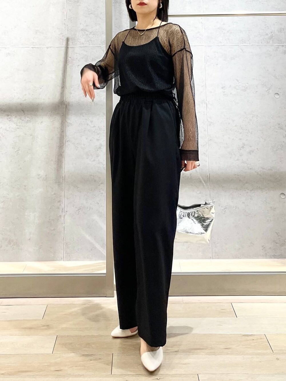 シルバー系のハンドバッグ、ブラック系のシャツ/ブラウス、ブラック系のスラックスを着用したレディースの冬コーディネートの9枚目の写真