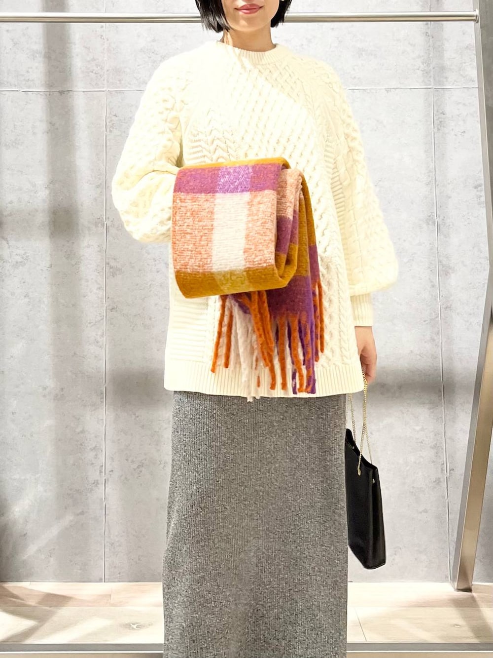 ブラック系のショルダーバッグ、ブラック系のブーツ、ホワイト系のその他トップスを着用したレディースの秋コーディネートの2枚目の写真