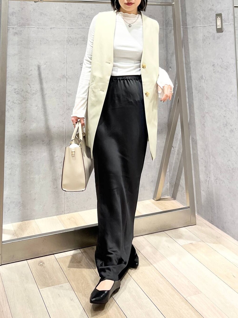 ホワイト系のTシャツ/カットソー、ブラック系のスカート、ホワイト系のショルダーバッグを着用したレディースの冬コーディネートの6枚目の写真