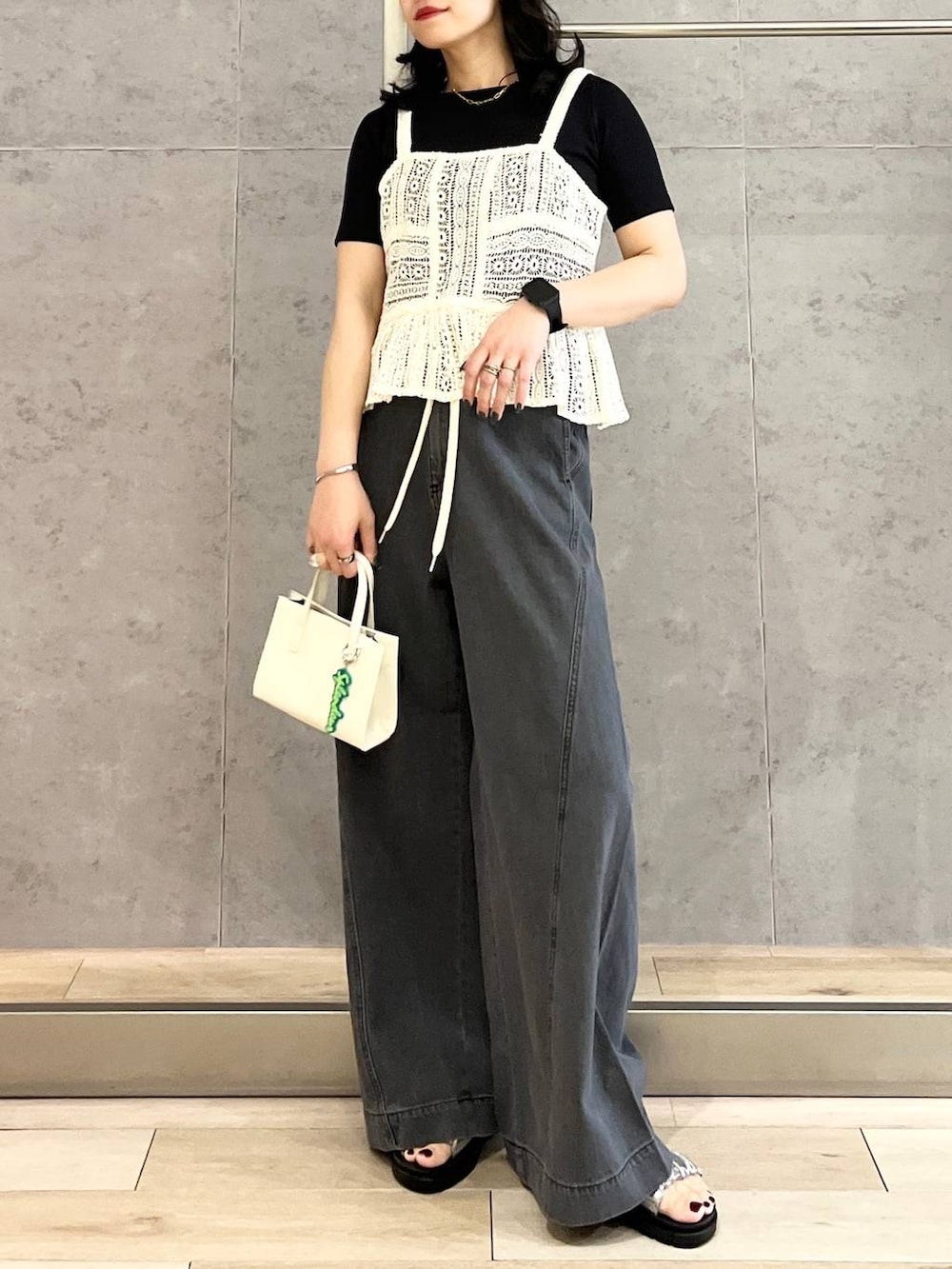 ブラック系のTシャツ/カットソー、シルバー系のサンダル、ブラック系のデニムパンツを着用したレディースの春コーディネートの3枚目の写真