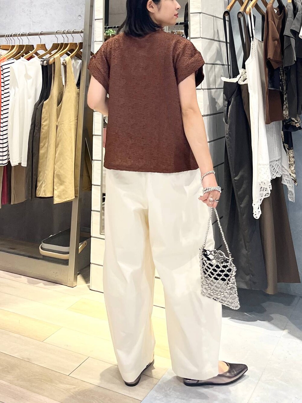 シルバー系のショルダーバッグ、ブラウン系のTシャツ/カットソー、ホワイト系のその他パンツを着用したレディースの夏コーディネートの4枚目の写真