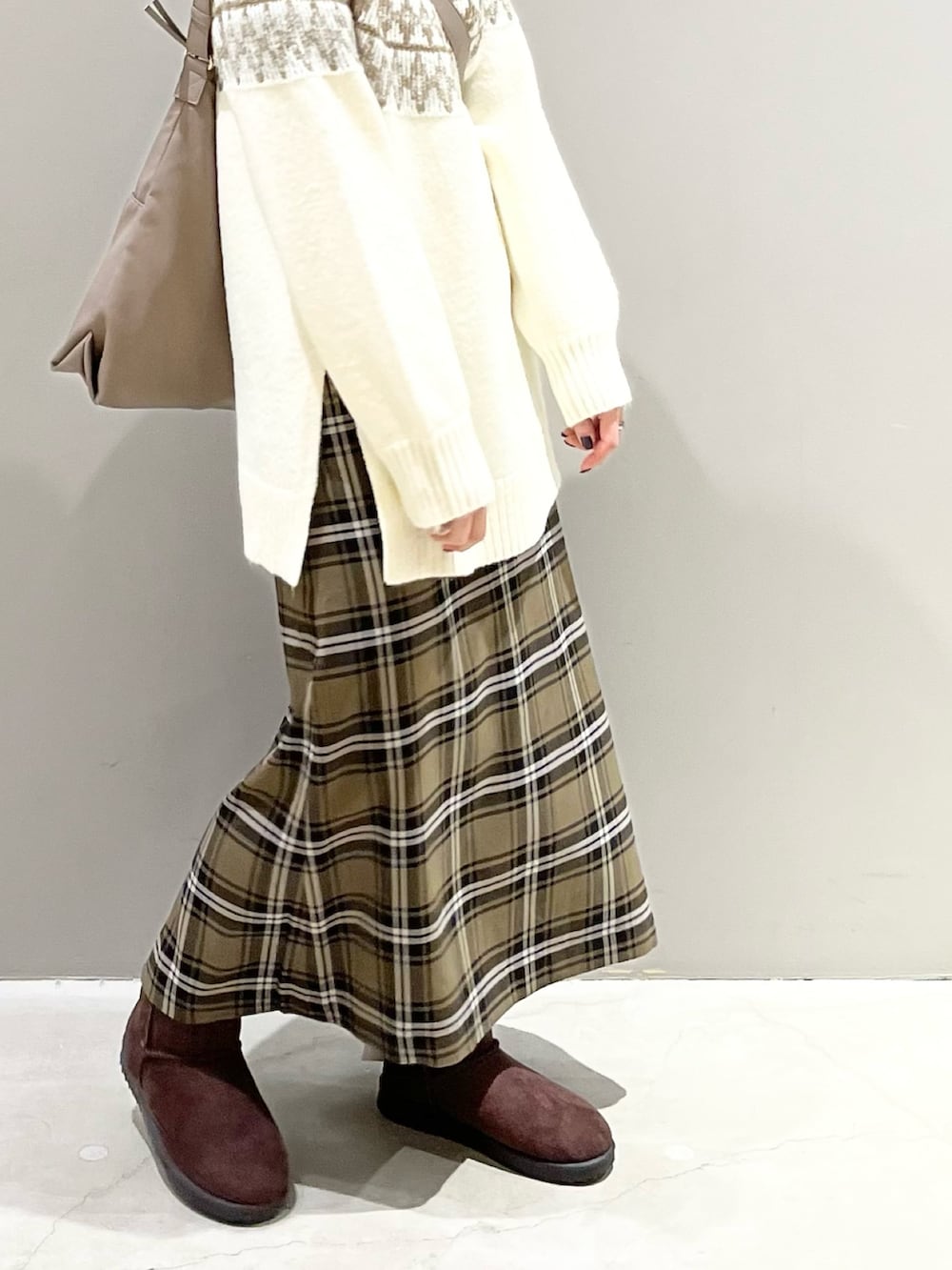 ブラウン系のスカート、ブラウン系のブーツ、ベージュ系のショルダーバッグを着用したレディースの冬コーディネートの4枚目の写真