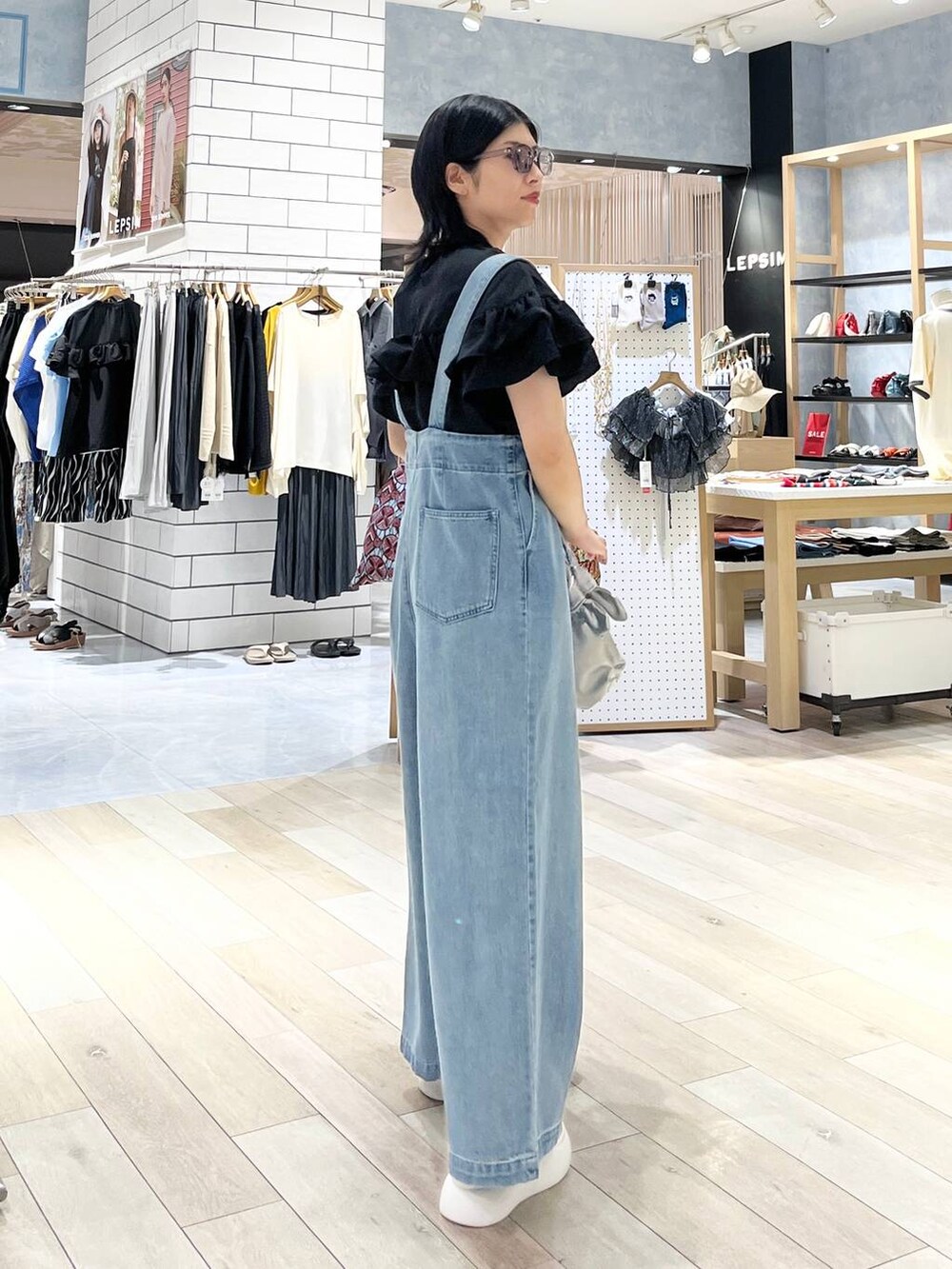 ホワイト系のサンダル、ブルー系のデニムパンツ、シルバー系のショルダーバッグを着用したレディースの夏コーディネートの8枚目の写真