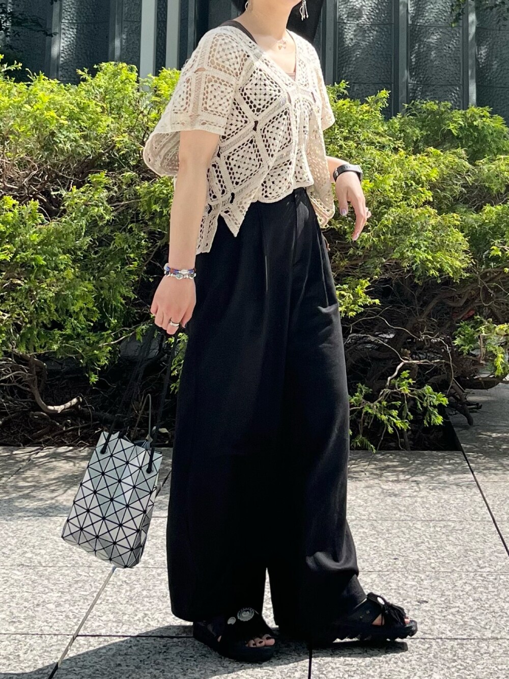 ブラック系のサンダル、ブラック系のその他パンツ、ホワイト系のTシャツ/カットソーを着用したレディースの春コーディネートの2枚目の写真