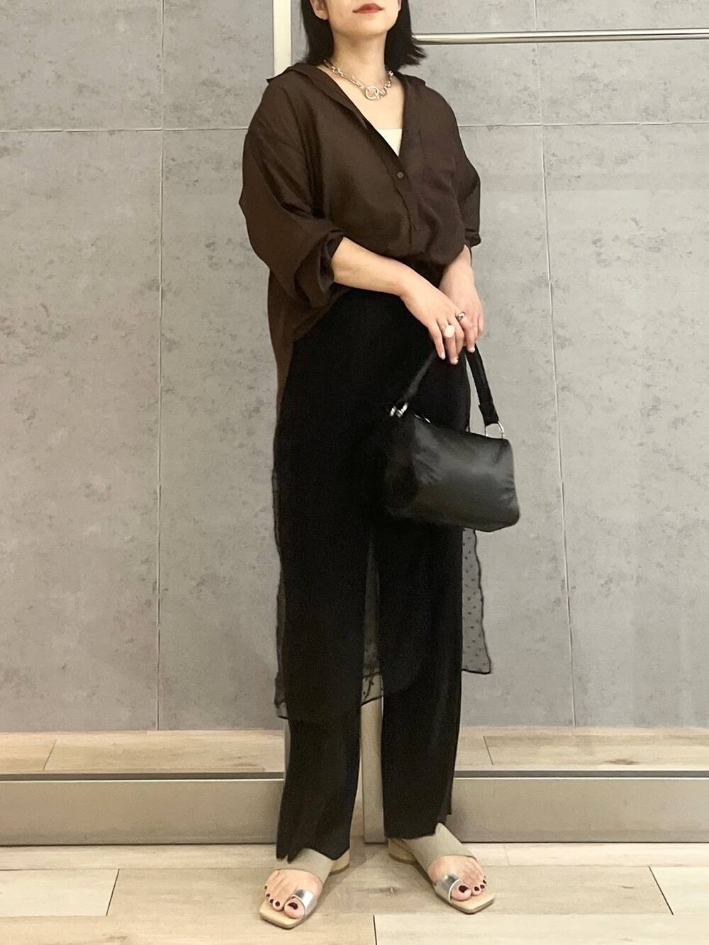 ホワイト系のタンクトップ、ブラック系のハンドバッグ、ブラック系のその他パンツを着用したレディースの夏コーディネートの2枚目の写真