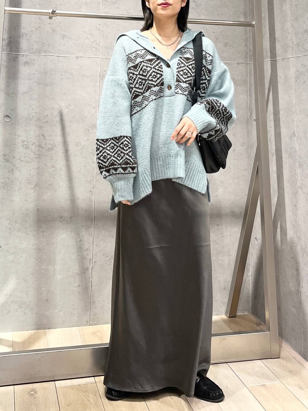 ブラック系のショルダーバッグ、グレー系のスカート、ブラック系のローファーを着用したレディースの秋コーディネートの7枚目の写真