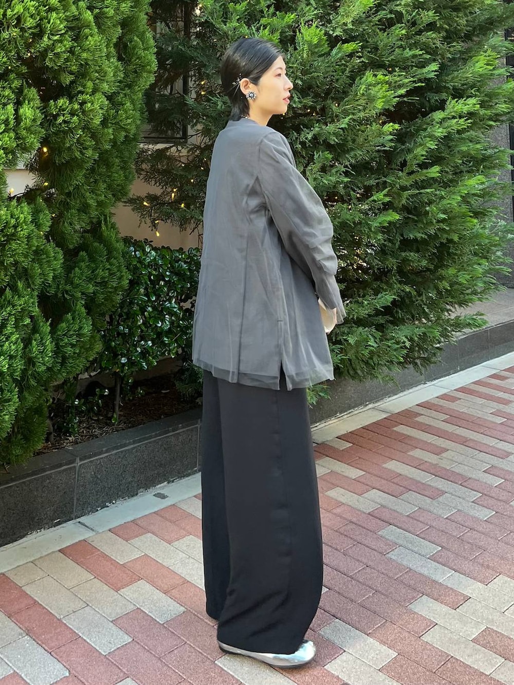グレー系のノーカラージャケット、ブラック系のつなぎ/オールインワン、シルバー系のネックレスを着用したレディースの冬コーディネートの3枚目の写真