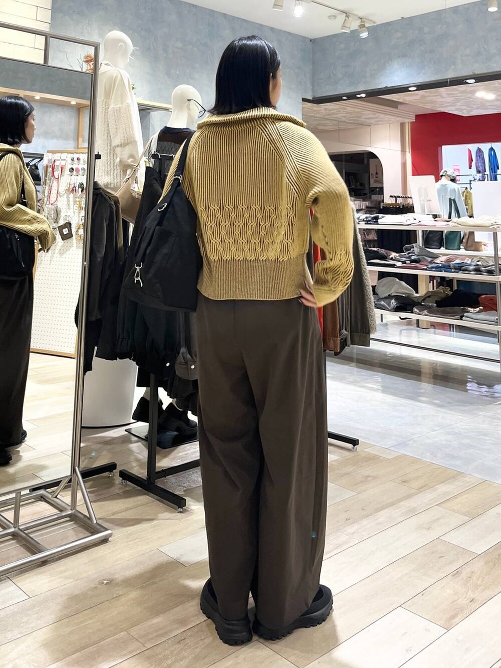 ブラウン系のその他パンツ、ブラック系のその他シューズ、ブラック系のショルダーバッグを着用したレディースの冬コーディネートの4枚目の写真