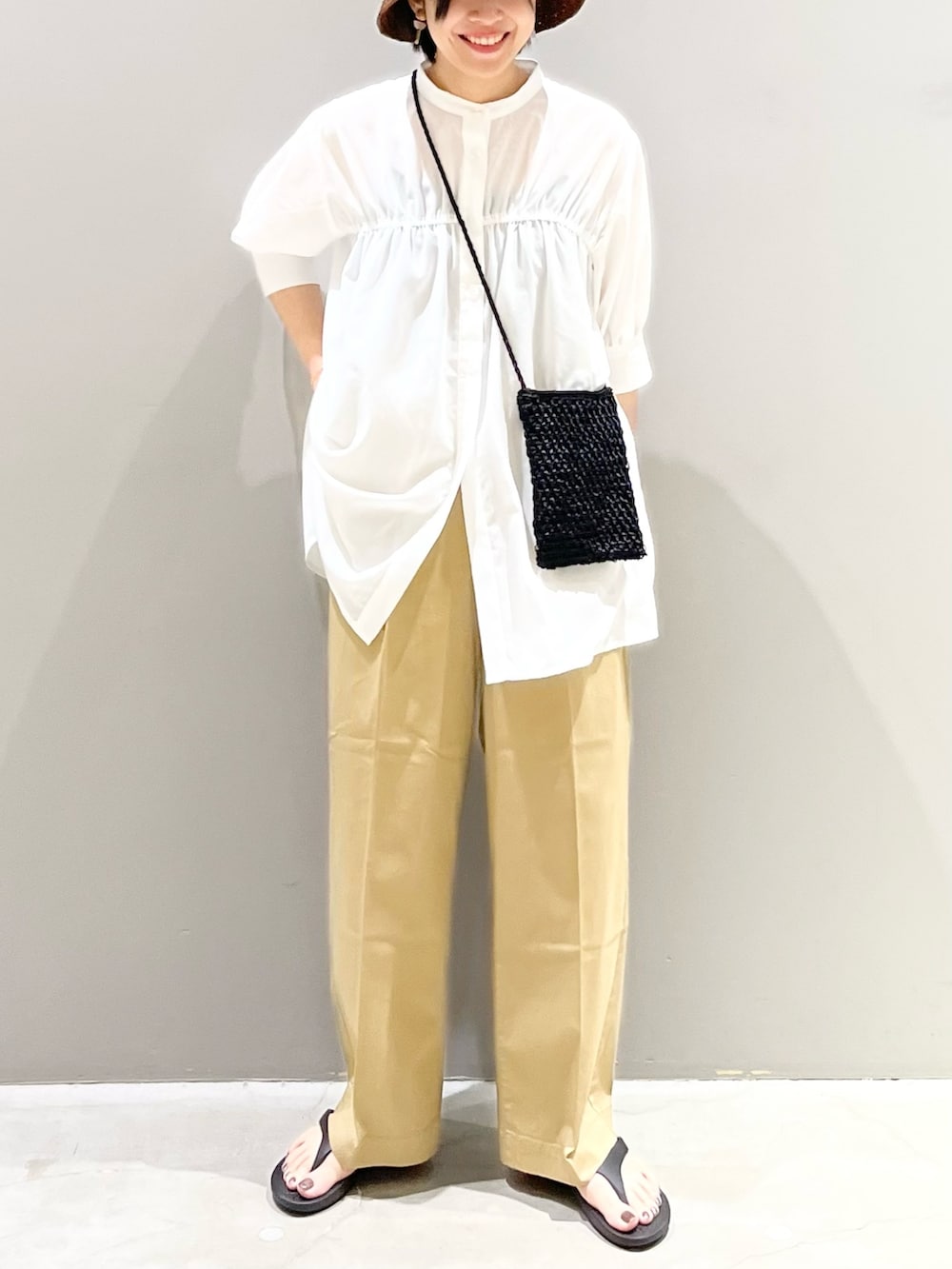 ブラック系のサンダル、ベージュ系のチノパンツ、ブラック系のショルダーバッグを着用したレディースの夏コーディネートの2枚目の写真