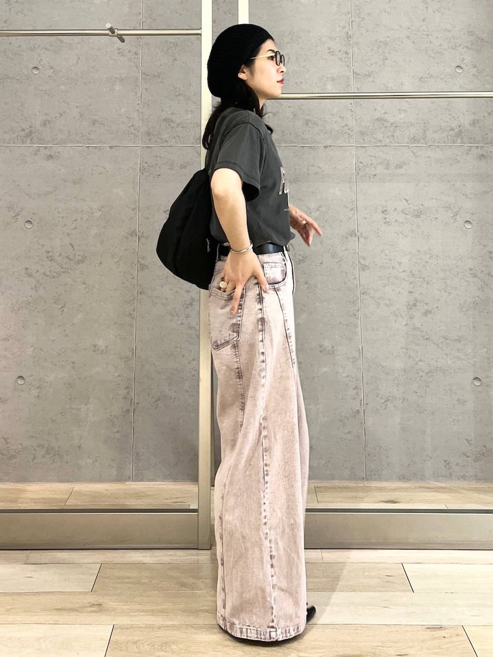 パープル系のデニムパンツ、ブラック系のショルダーバッグ、ブラック系のTシャツ/カットソーを着用したレディースの春コーディネートの4枚目の写真