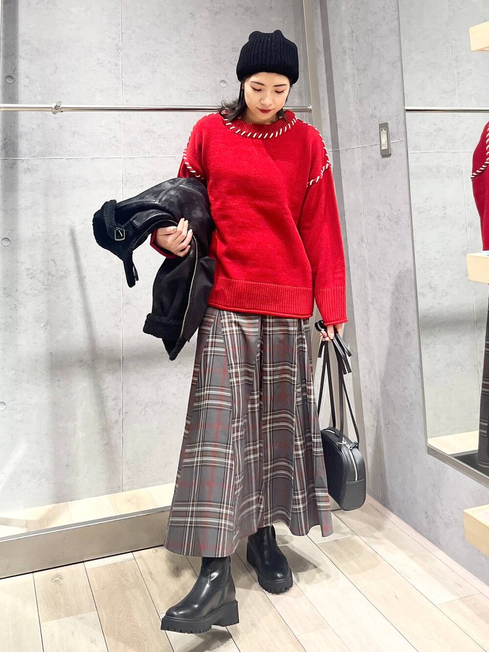 ブラック系のブーツ、ブラック系のその他アウター、グレー系のスカートを着用したレディースの冬コーディネートの3枚目の写真