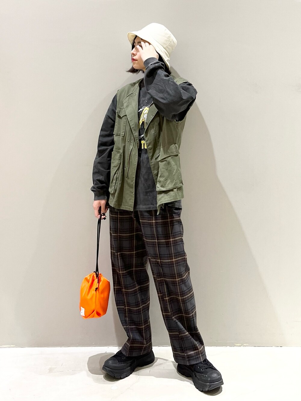 ブラウン系のスラックス、ブラック系のスニーカー、グリーン系のジャケット/アウターを着用したレディースの春コーディネートの5枚目の写真