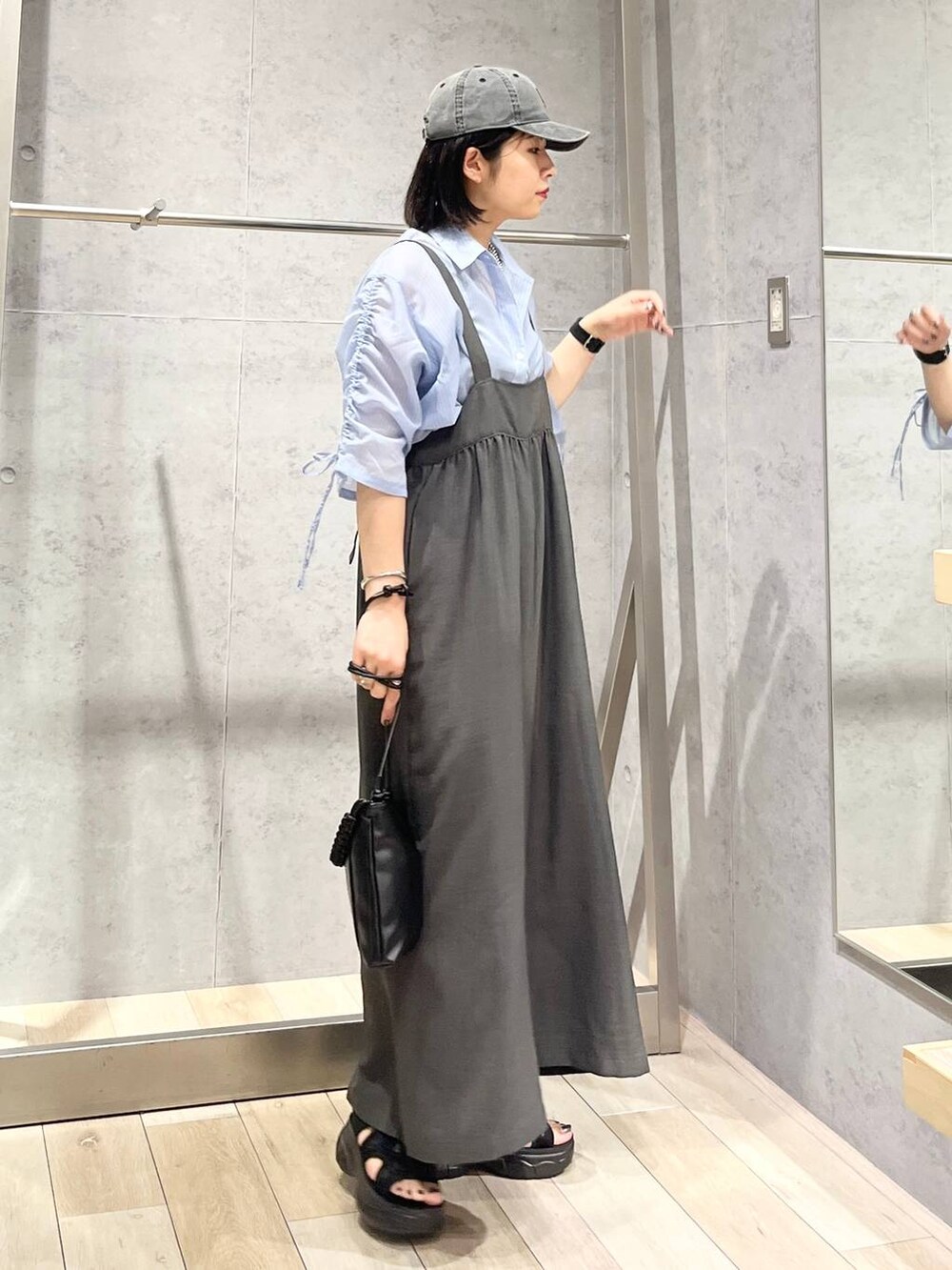 グレー系のサロペット/オーバーオール、ブラック系のサンダル、ブラック系のショルダーバッグを着用したレディースの夏コーディネートの4枚目の写真