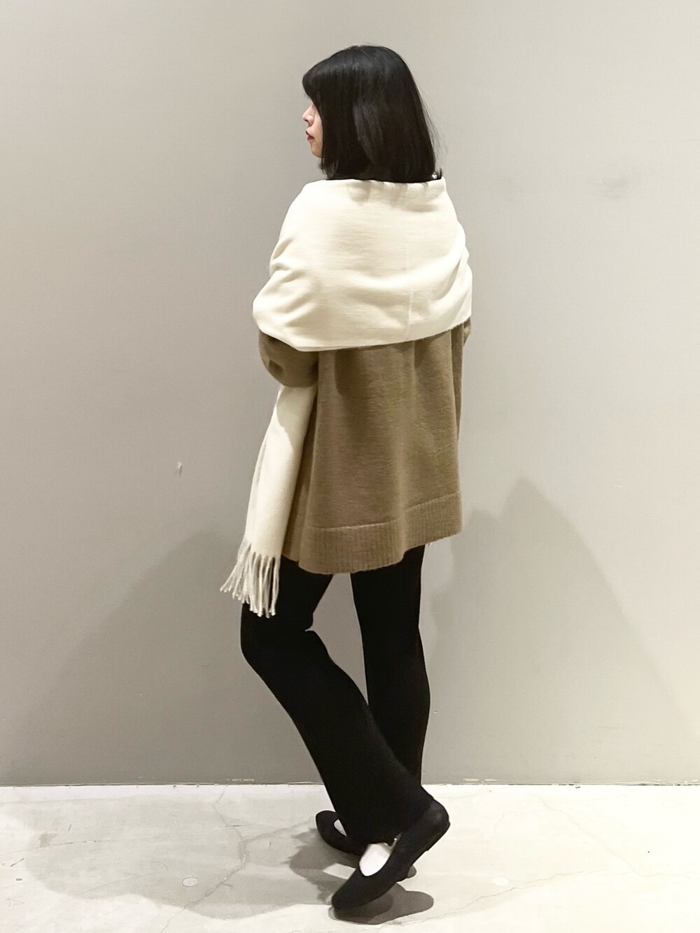 ブラック系のその他パンツ、ブラック系のパンプス、ホワイト系のストール/ショールを着用したレディースの秋コーディネートの2枚目の写真