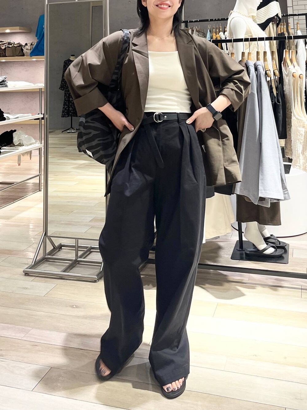 ブラック系のサンダル、グレー系のトートバッグ、ホワイト系のキャミソールを着用したレディースの夏コーディネートの2枚目の写真