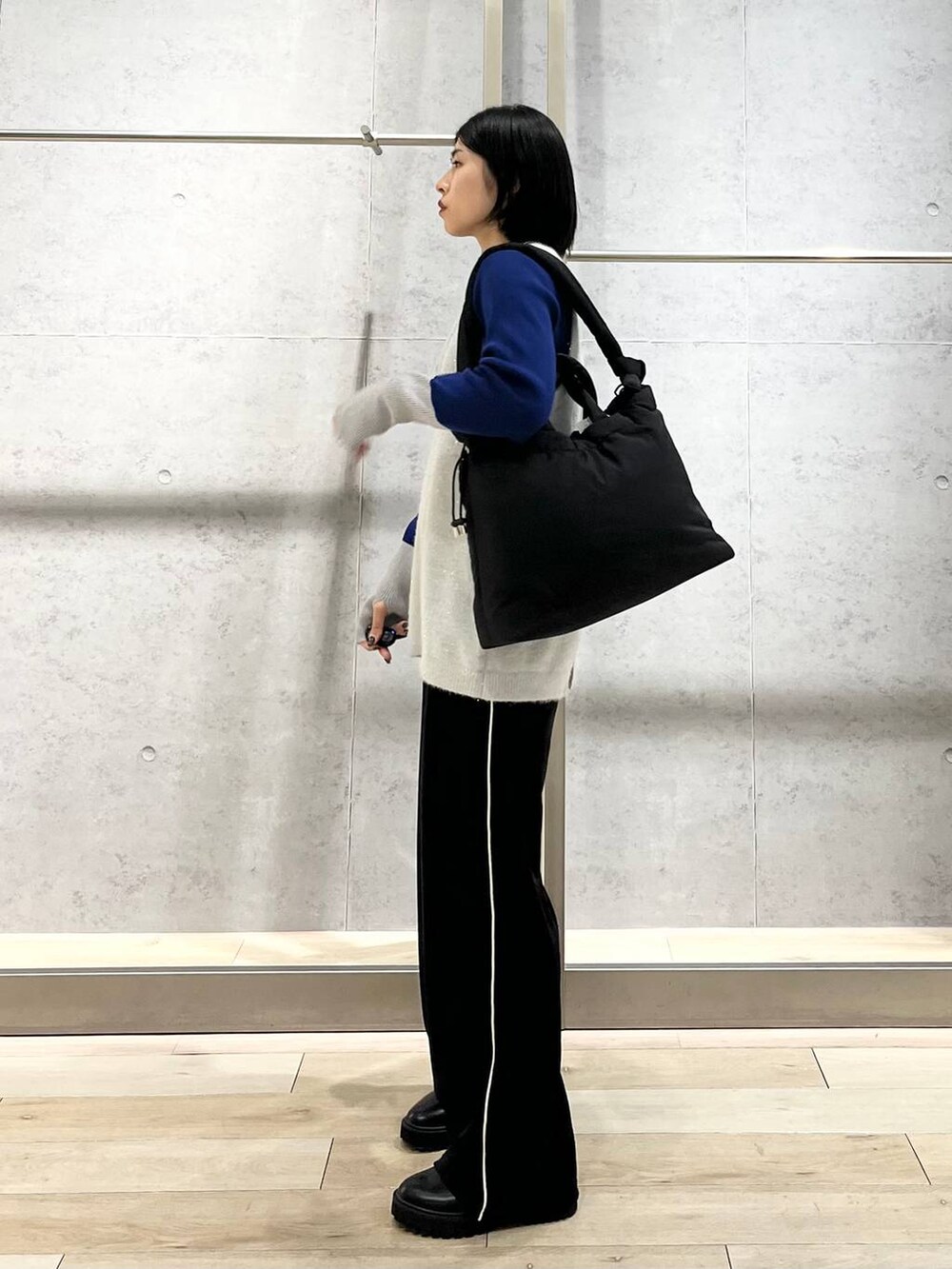 ブラック系のブーツ、ブルー系のニット/セーター、ブラック系のその他パンツを着用したレディースの冬コーディネートの4枚目の写真