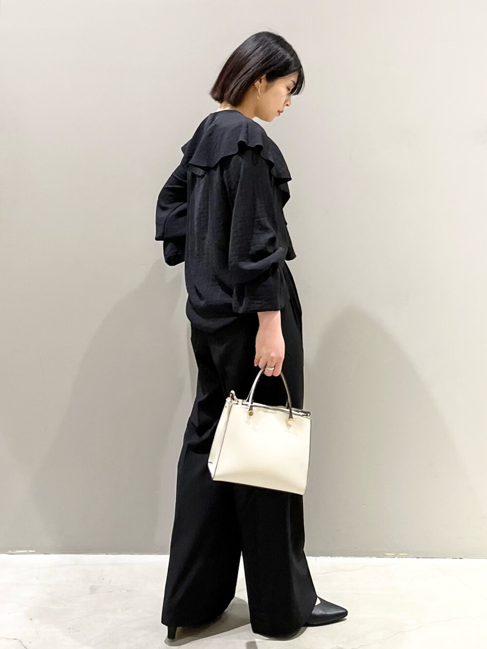 ブラック系のシャツ/ブラウス、ブラック系のバッグ、ブラック系のパンツを着用したレディースの春コーディネートの3枚目の写真