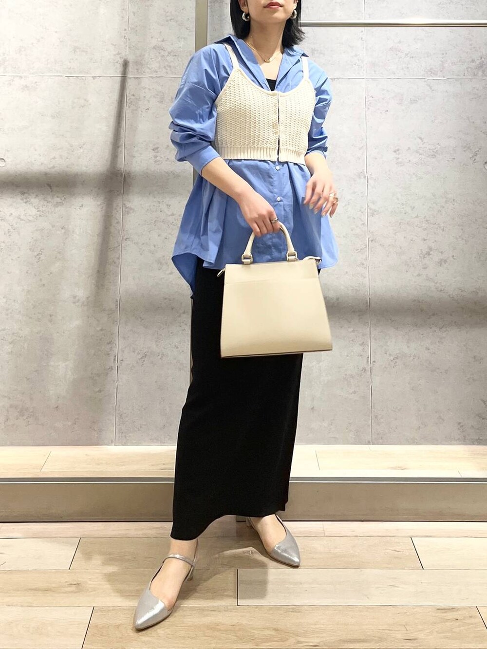 ブルー系のシャツ/ブラウス、ブラック系のスカート、ホワイト系のショルダーバッグを着用したレディースの冬コーディネートの2枚目の写真