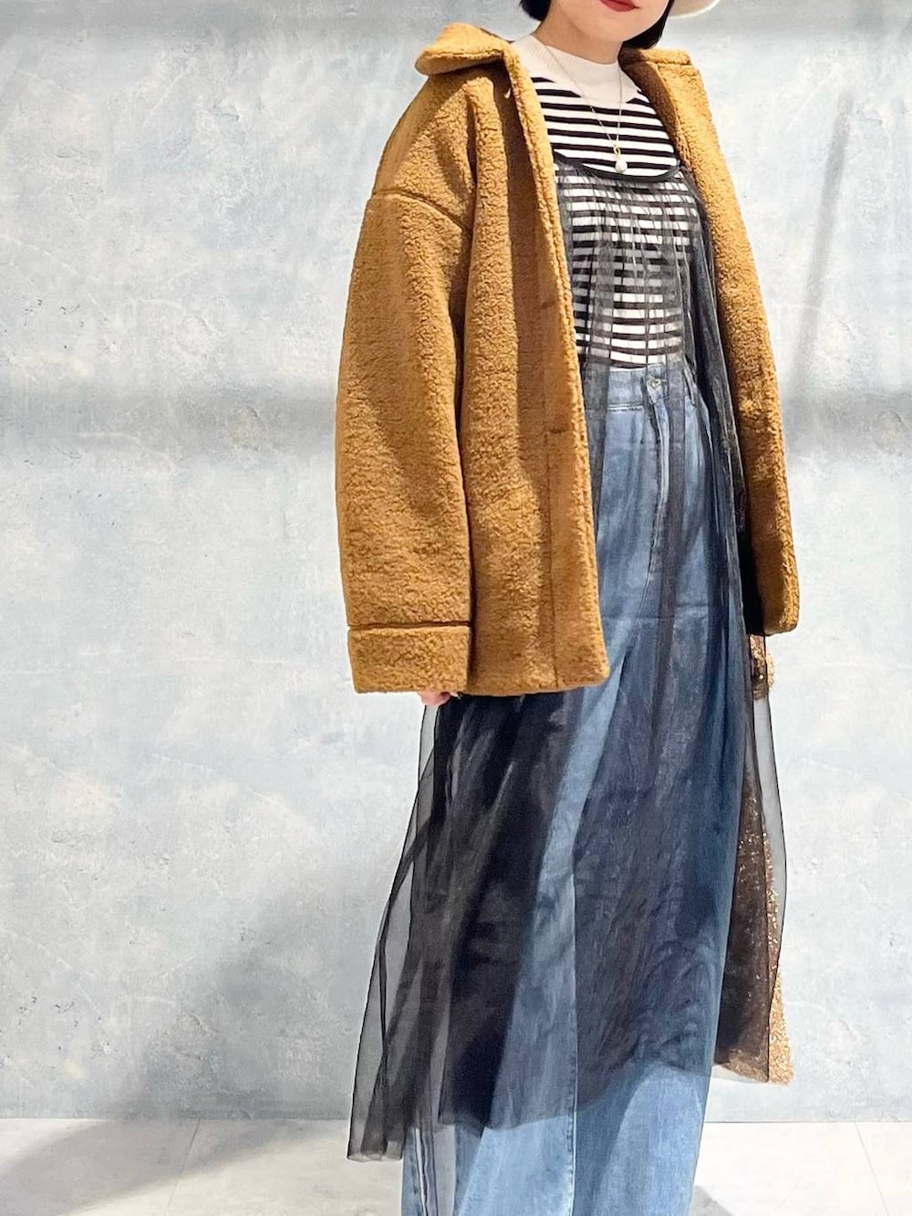 ブラウン系のブルゾン、ブラック系のモカシン/デッキシューズ、ゴールド系のショルダーバッグを着用したレディースの冬コーディネートの2枚目の写真