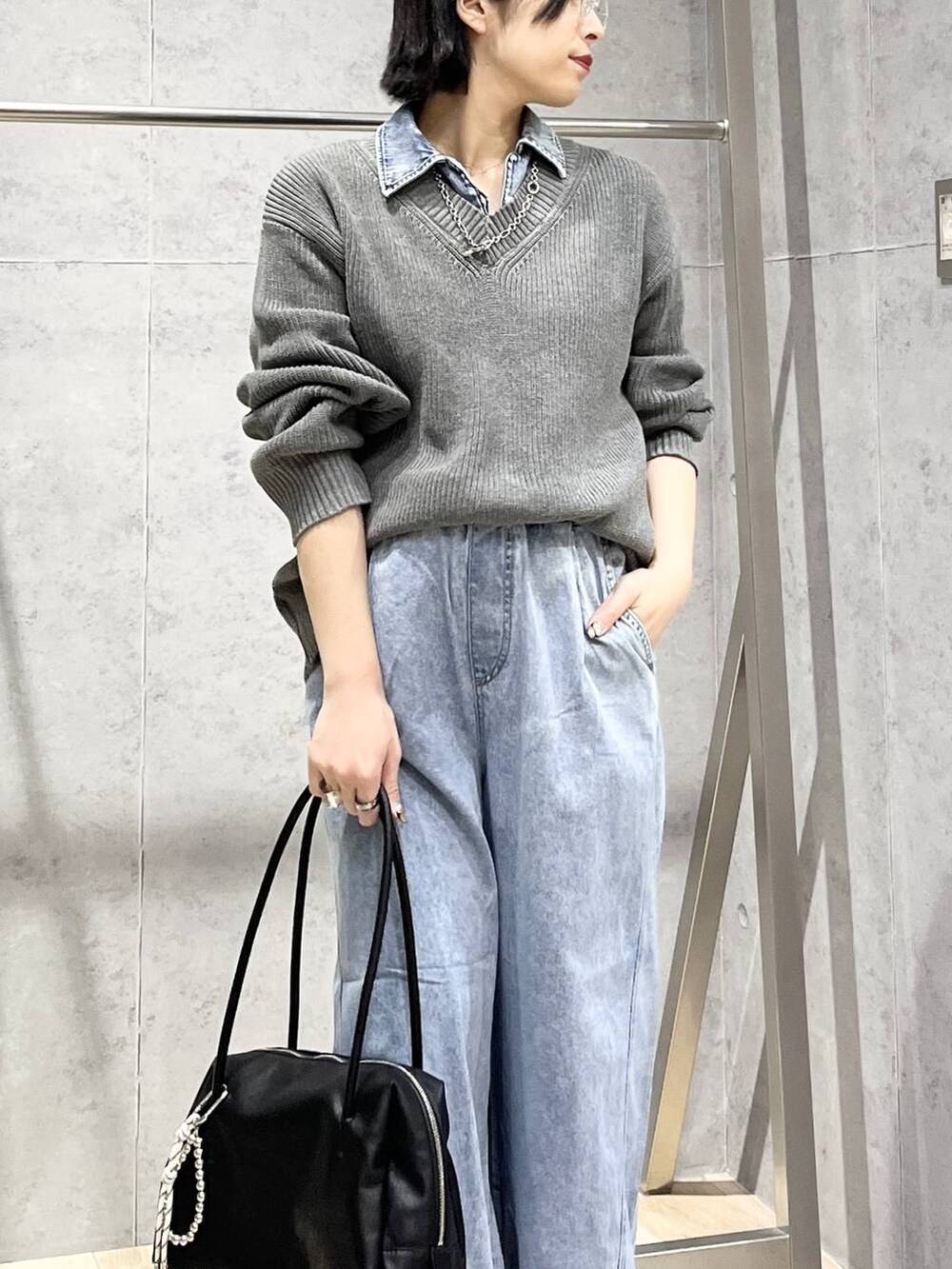 ブラック系のサンダル、ブルー系のデニムパンツ、ブラック系のボストンバッグを着用したレディースの冬コーディネートの2枚目の写真