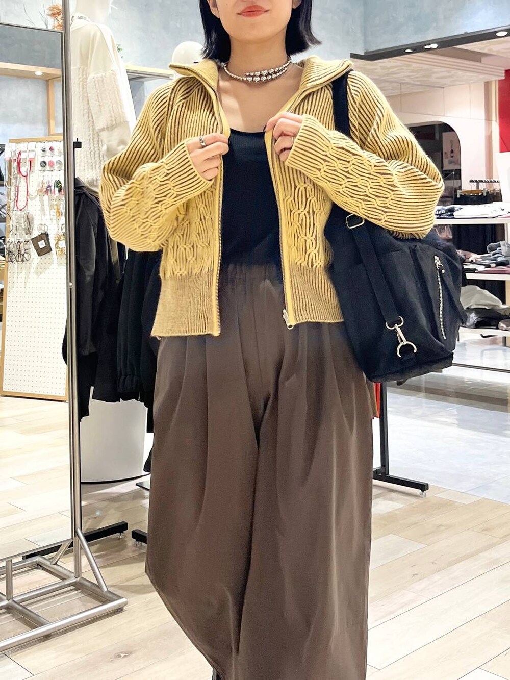 ブラウン系のその他パンツ、ブラック系のその他シューズ、ブラック系のショルダーバッグを着用したレディースの冬コーディネートの2枚目の写真
