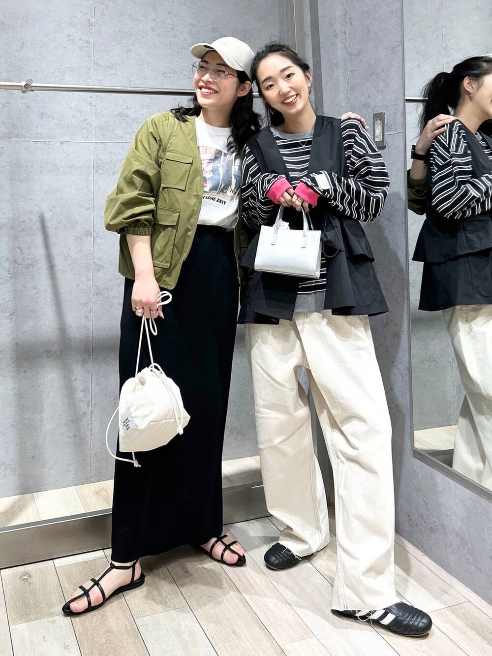 ブラック系のスカート、ホワイト系のショルダーバッグ、ブラック系のサンダルを着用したレディースの春コーディネートの2枚目の写真