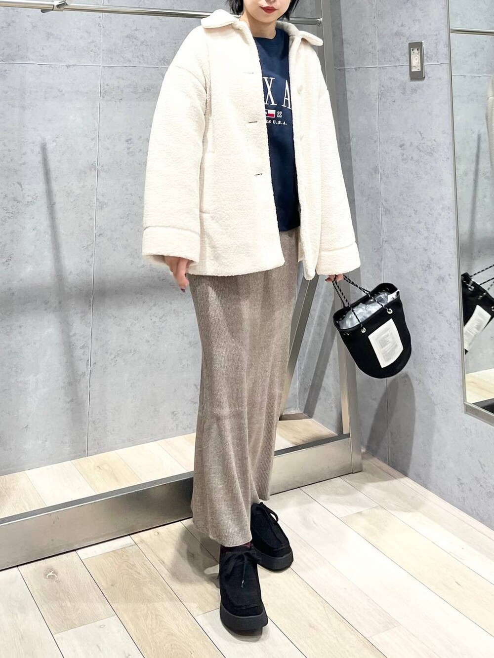 ブルー系のTシャツ/カットソー、ホワイト系のブルゾン、ブラック系のモカシン/デッキシューズを着用したレディースの秋コーディネートの2枚目の写真