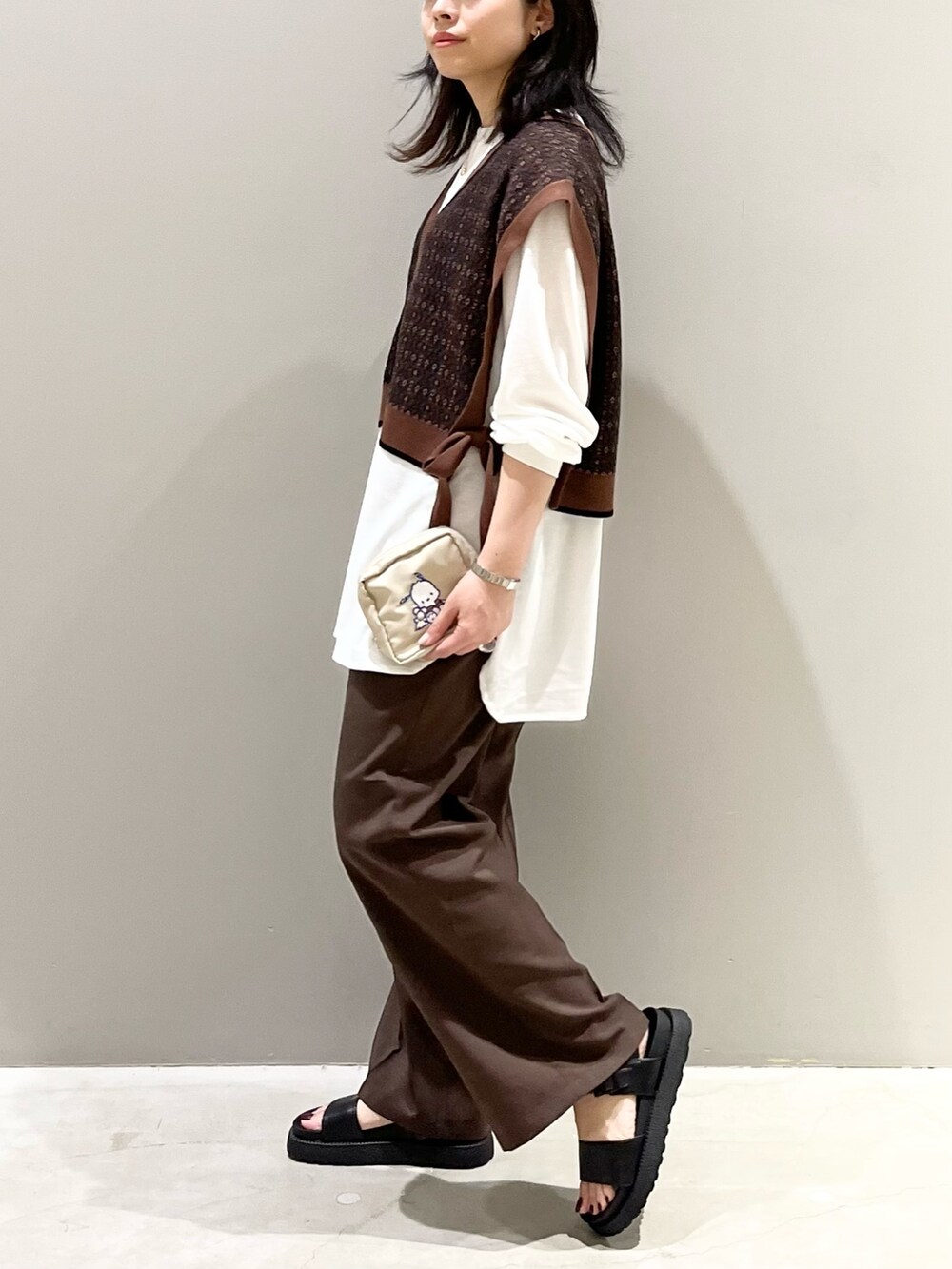 ブラウン系のスラックス、ブラック系のサンダル、ブラウン系のマタニティウェア/グッズを着用したレディースの秋コーディネートの2枚目の写真