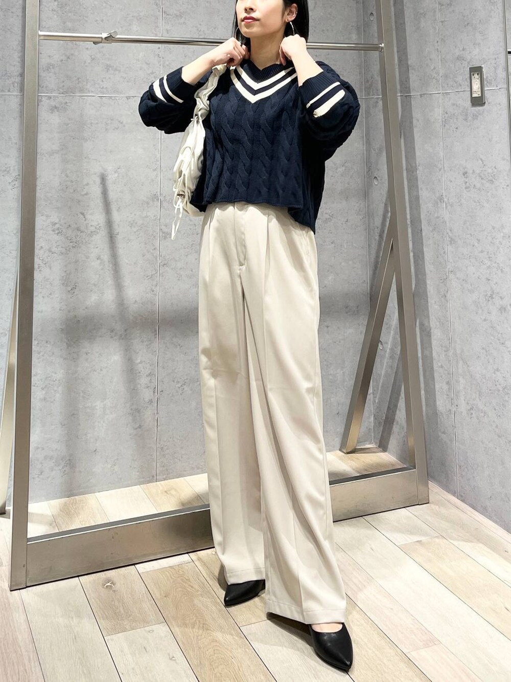 ブルー系のニット/セーター、ホワイト系のショルダーバッグ、ブラック系のパンプスを着用したレディースの冬コーディネートの6枚目の写真