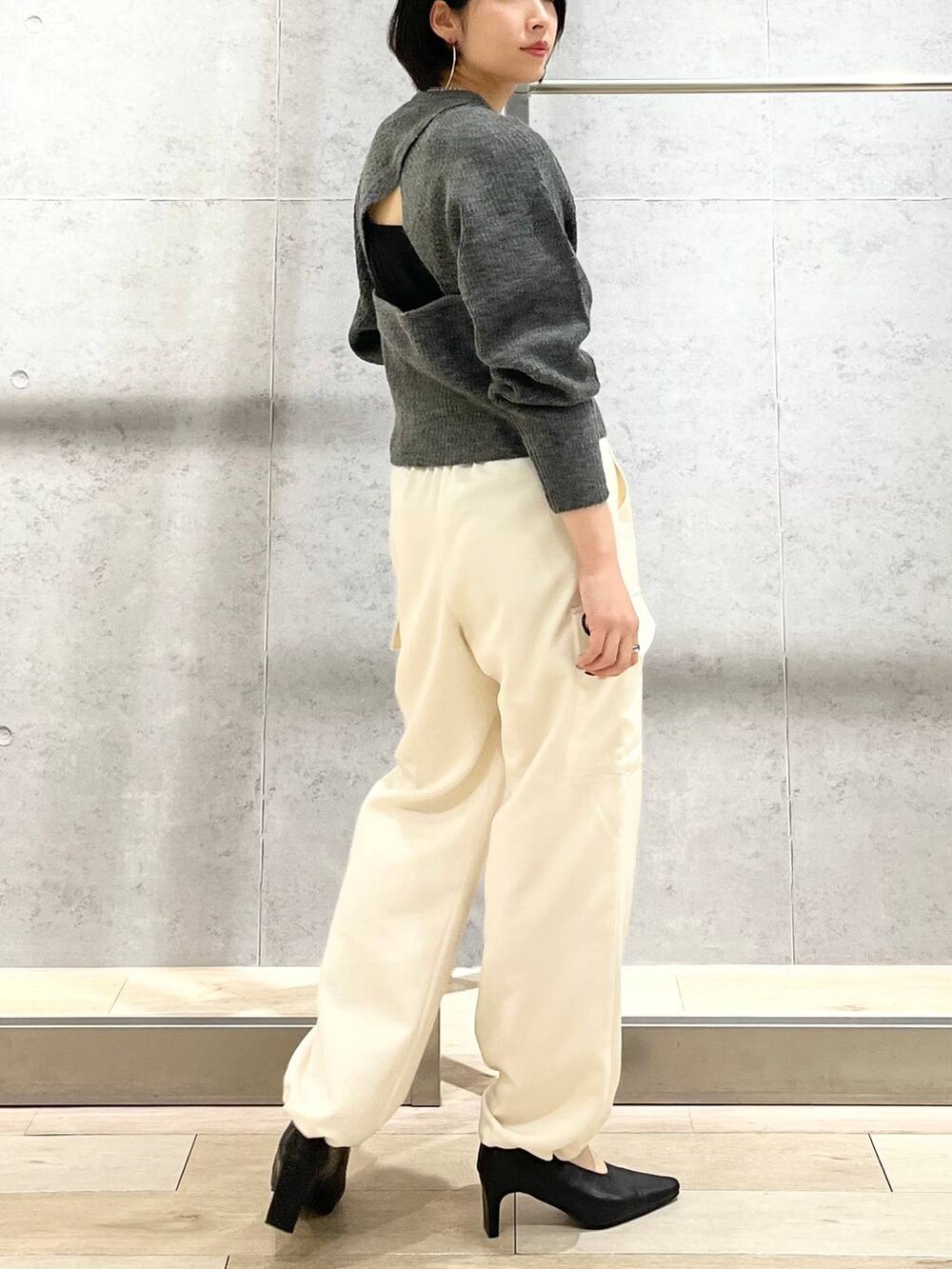 ブラック系のショルダーバッグ、ブラック系のパンプス、グレー系のニット/セーターを着用したレディースの秋コーディネートの4枚目の写真