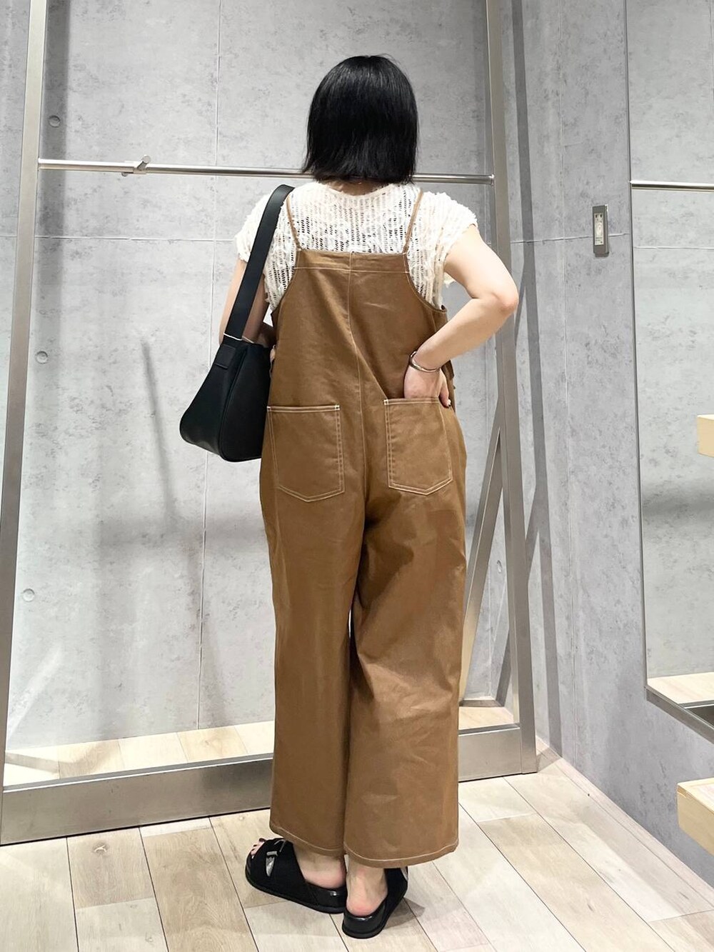 ブラック系のサンダル、ホワイト系のその他トップス、ブラック系のショルダーバッグを着用したレディースの夏コーディネートの3枚目の写真