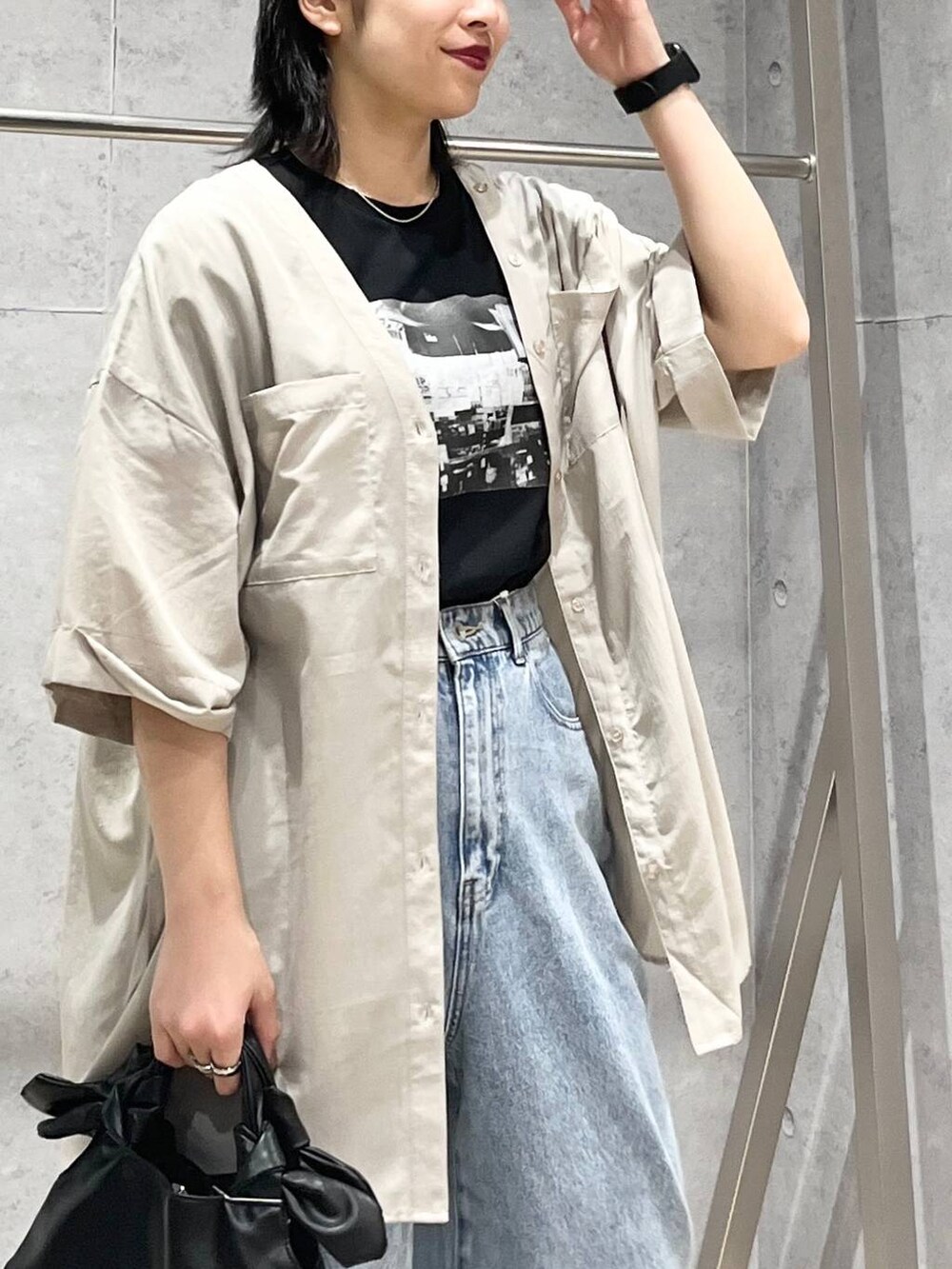 ブラック系のTシャツ/カットソー、ブラック系のサンダル、ブルー系のデニムパンツを着用したレディースの夏コーディネートの7枚目の写真