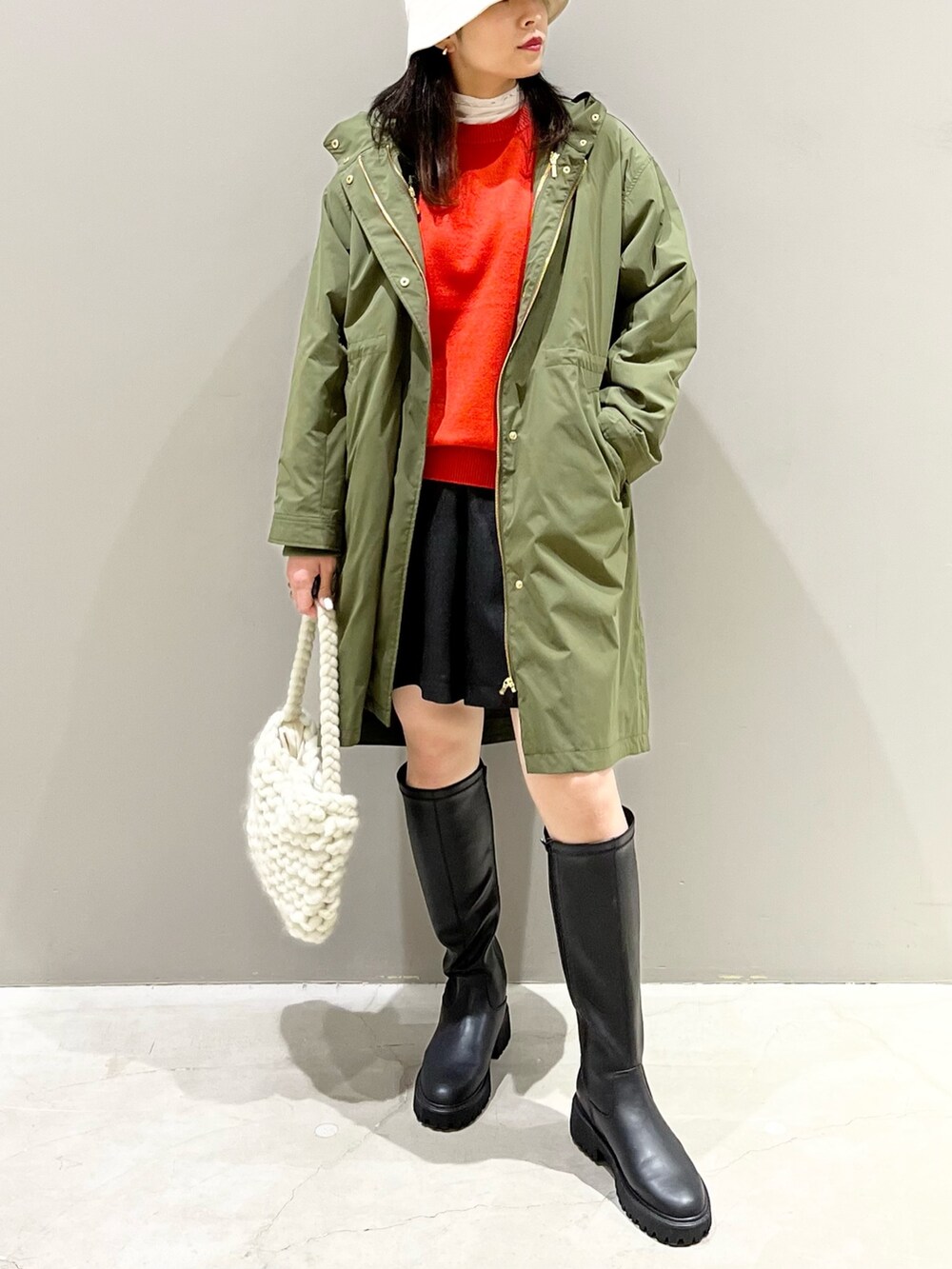 ブラック系のパンツ、ブラック系のブーツ、ホワイト系のバッグを着用したレディースの秋コーディネートの2枚目の写真