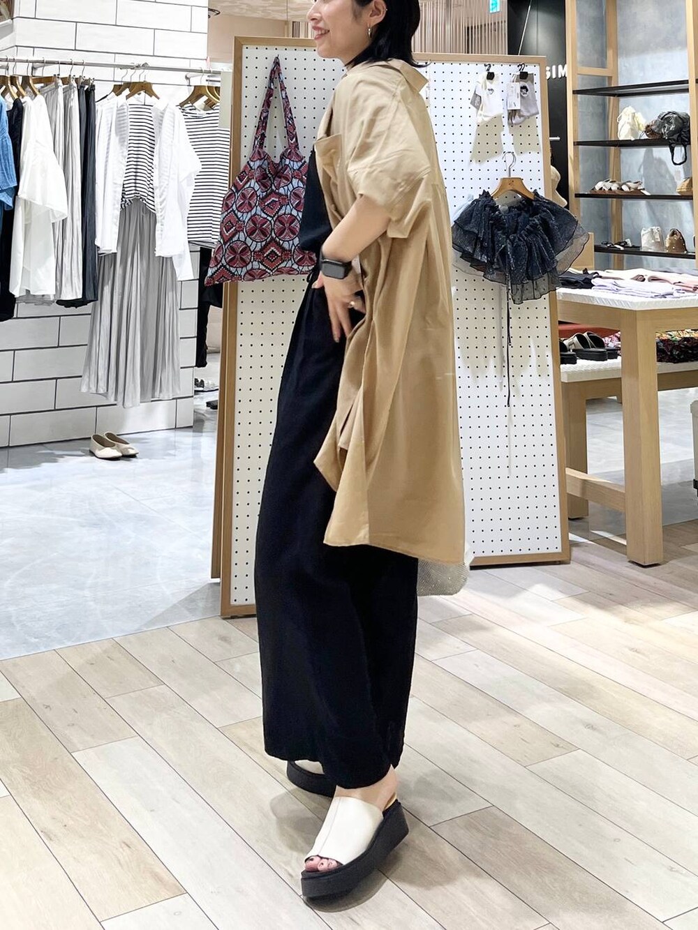 シルバー系のショルダーバッグ、ブラック系のその他パンツ、ホワイト系のサンダルを着用したレディースの夏コーディネートの3枚目の写真